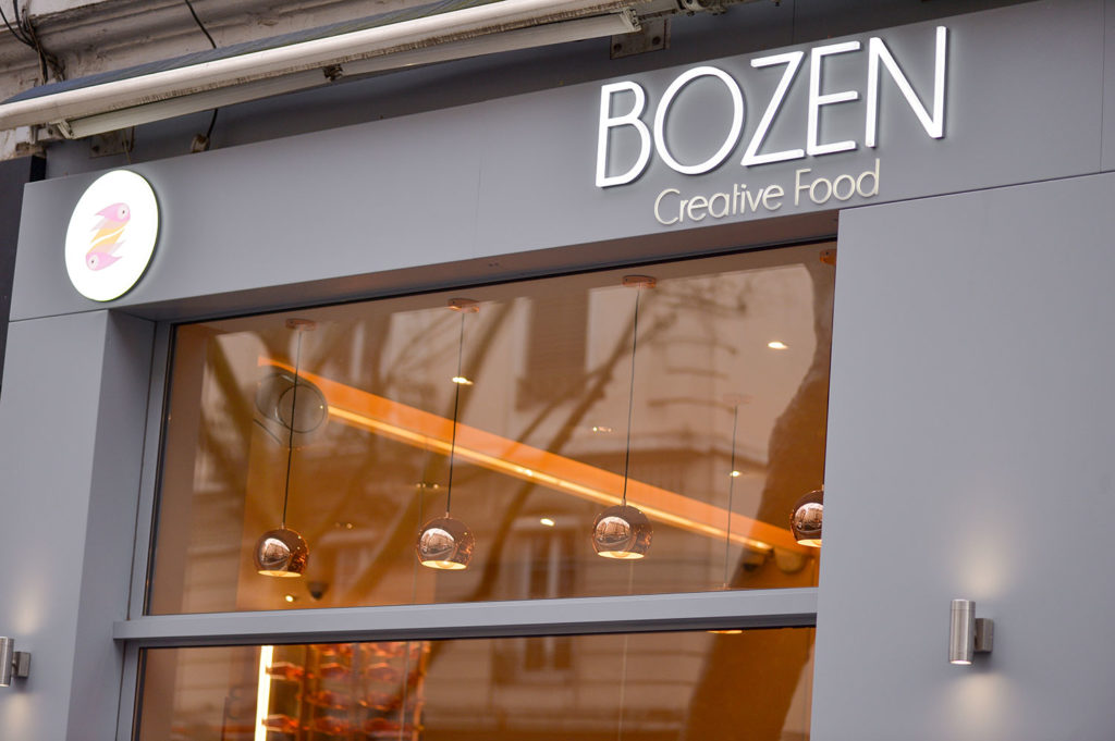 Devanture vitrée en menuiserie aluminium du restaurant Bozen avec enseigne lumineuse